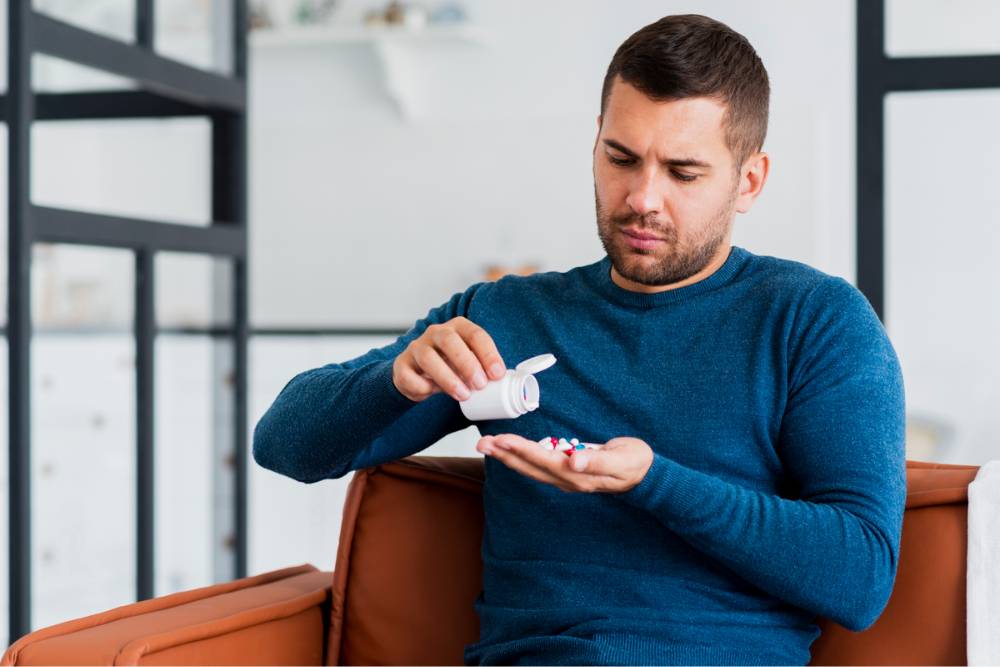 A concerned man examining pills, symbolizing the personal struggles addressed through Opioid Addiction Treatment in New Jersey.