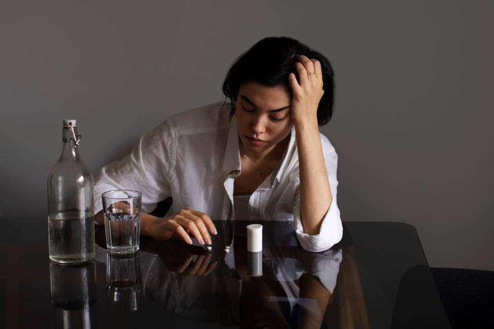 A distressed woman facing medication misuse, representing the emotional toll and urgency of seeking Opioid Addiction Treatment in New Jersey.