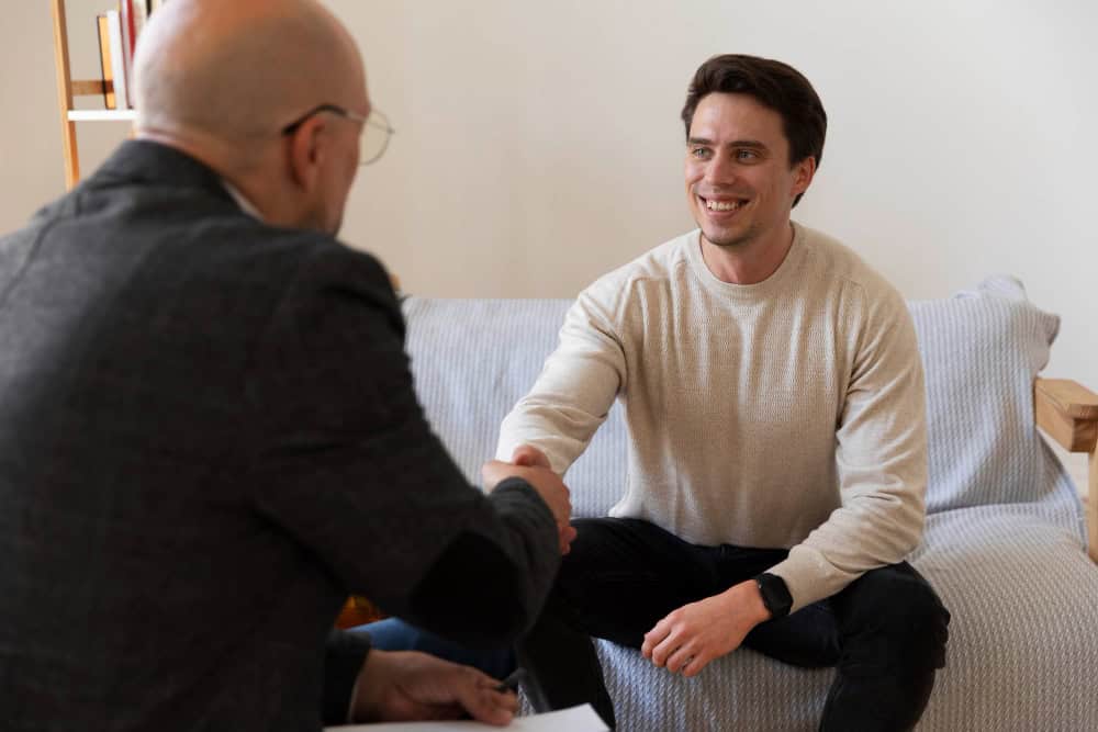 A man in a therapy session speaking with a psychiatrist, symbolizing personalized treatment and emotional support as part of drug rehab in New Jersey.
